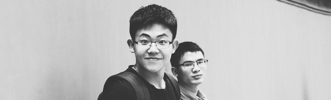 Schwarz-Weiß Bild von Zwei Jungs die Brille und Rucksack tragen 