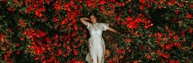 Person liegt in einer Blumenwiese