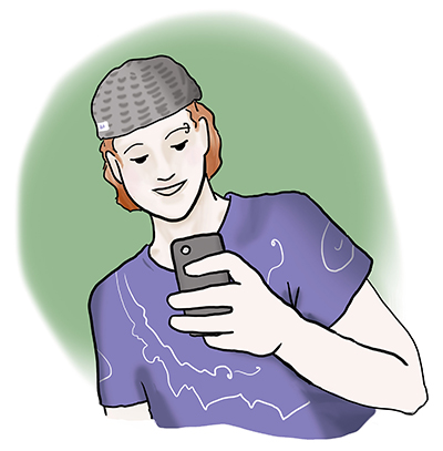 Ein Jugendlicher mit Kapuze schaut auf sein Handy